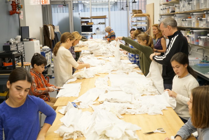 Volunteers cut up fabric remnants in the maker space.