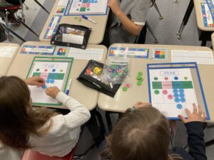 Young students learning maths with tokens